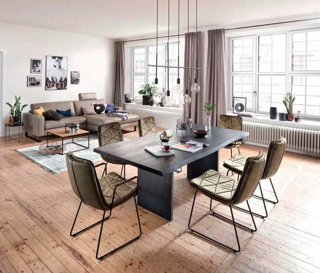 Wohnzimmer in Landhaus Stil mit massivem Esstisch und beigem Sofa, auf einem schönen Parkettboden