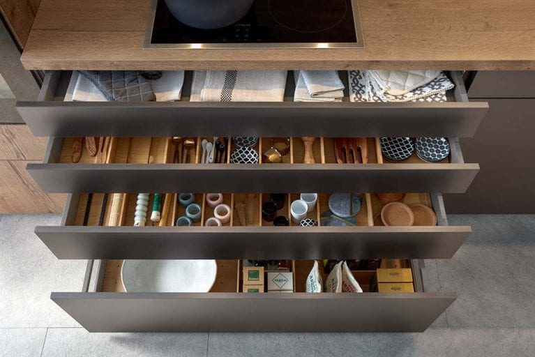 Ausgezogene Küchenschubladen mit verschiedenen Ordnungssystemen