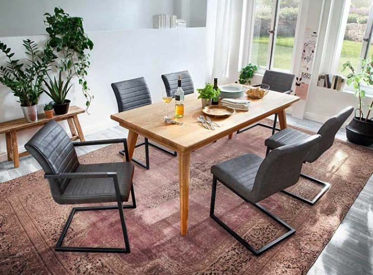 Freischwingerstühle Kian stehen um einen hölzernen Esstisch herum