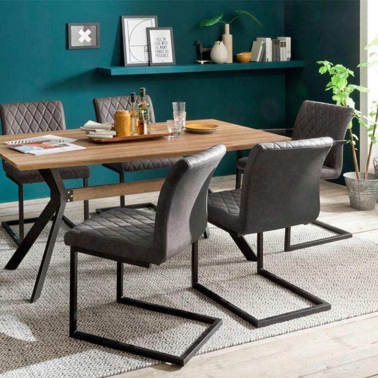 Retrostühle Kian in Anthrazit mit Rautenmuster stehen in einem petrolfarbenen Wohnzimmer am Esstisch