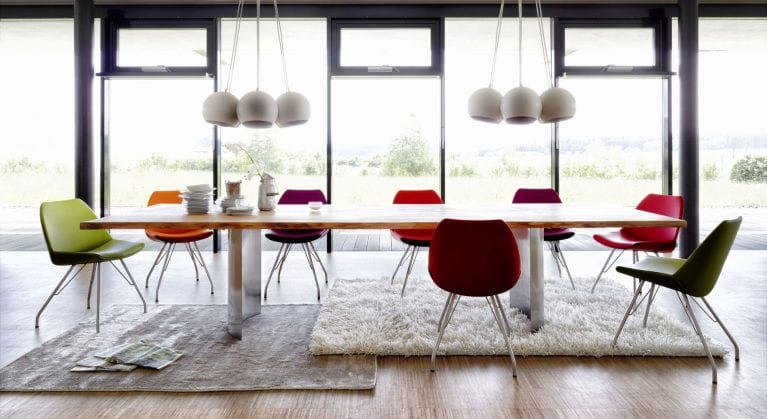 Langer Esstisch mitverschieden farbigen Contur Stühlen in grosser Wohnung