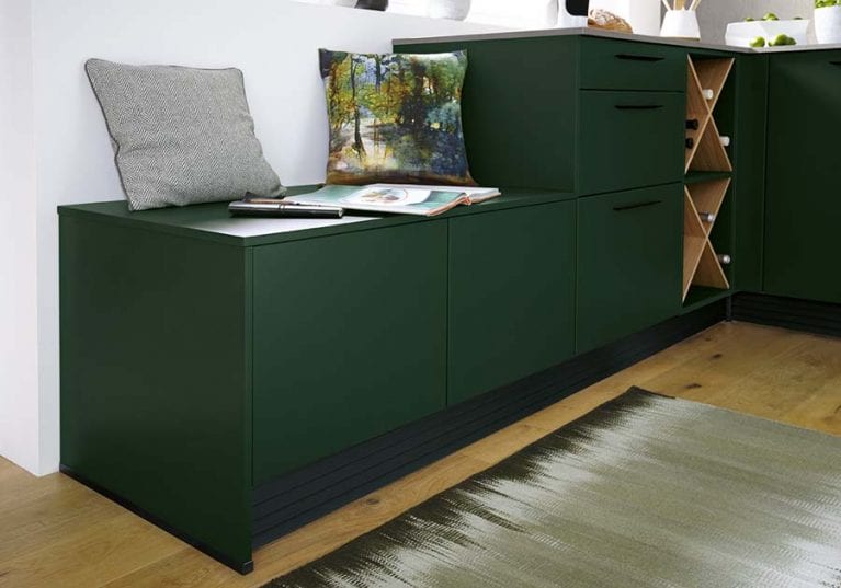 Waldgrüne Contur Küche mit integrierten Sitzschubladen und einem dezenten Weinregal aus Asteiche