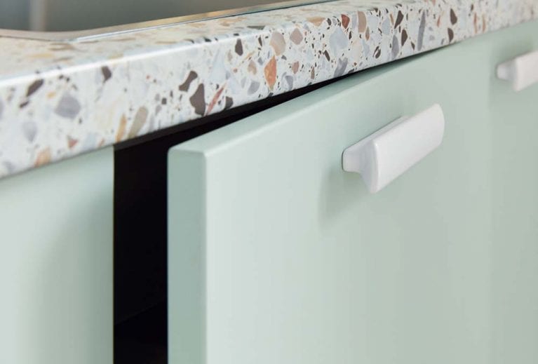 Arbeitsfläche in Terrazzo Urbano Nachbildung, Küchenfront in mintgün mit weissen Griffen