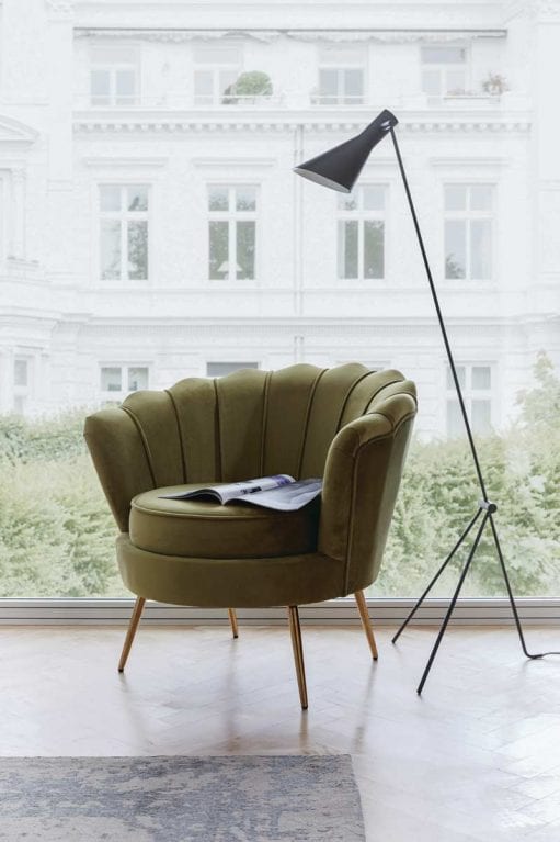 Olivgrüner antiker Sessel vor bodenlangem Fenster