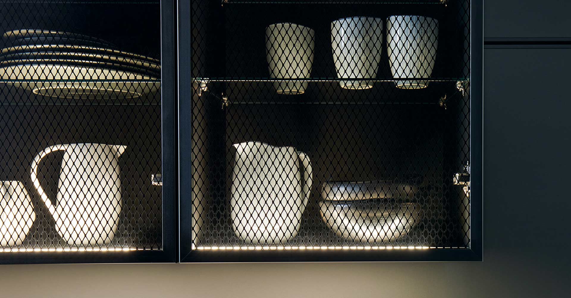 Glas-Küchenfront mit Rautenmuster und Geschirr im Hintergrund