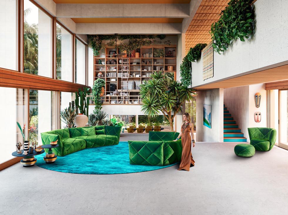 Bretz Sofa in Samtgrün mit Frau in orangenen Jumpsuit