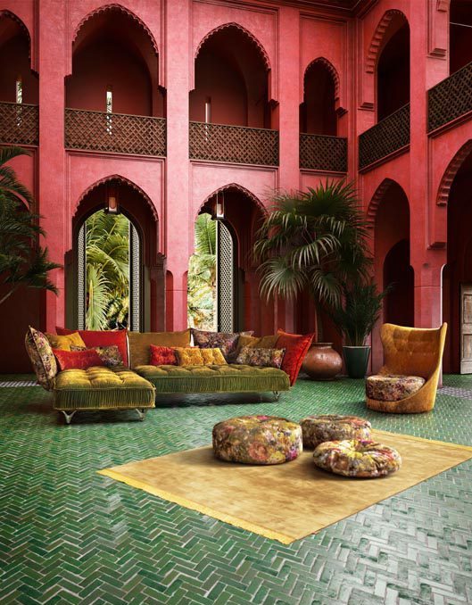 Orientalisches Wohnzimmer mit grünem Boden und roter Wand. In der Mitte steht Sofa Ohlinda