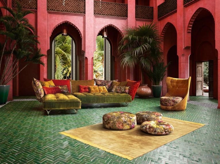 Orientalisches Wohnzimmer mit grünem Boden und roter Wand. In der Mitte steht Sofa Ohlinda