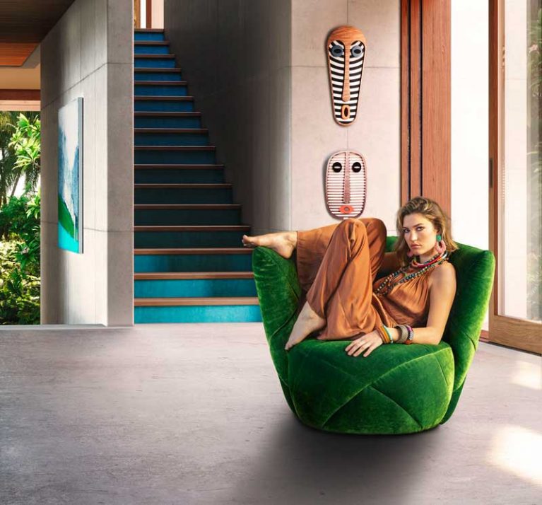 Bretz Sessel in Samtgrün mit Frau in orangenen Jumpsuit darauf