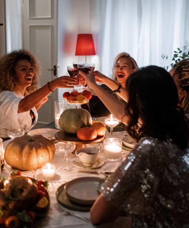 Abendessen mit Freunden, die zusammen mit einem Glas Wein anstossen.